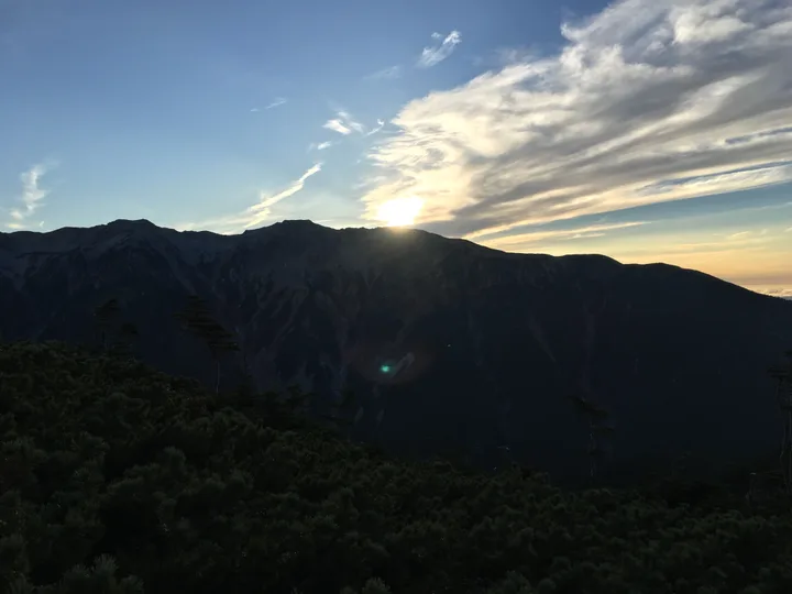 山の稜線に沈む夕日